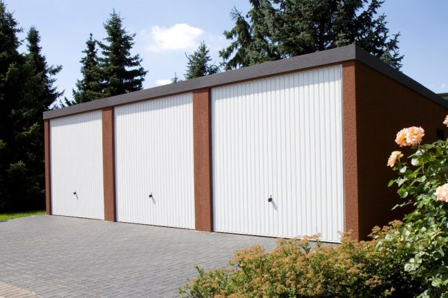 Trojgaráž s pultovou strechou a bielymi bránami