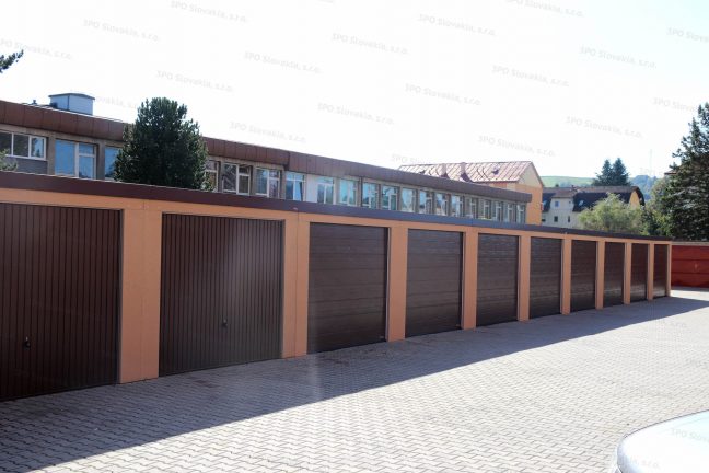 Moderná radová garáž v oranžovej omietke s bránami Hormann v hnedej farbe