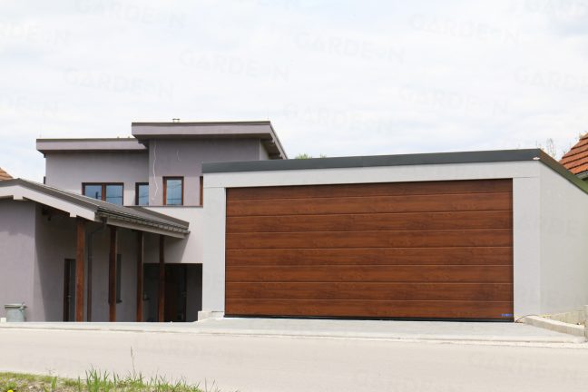Oceľová dvojgaráž v sivej omietke pri rodinnom dome