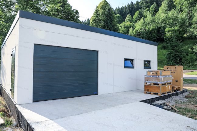 Montovaný oceľový sklad GARDEON v bielej omietke s antracitovou bránou Hormann