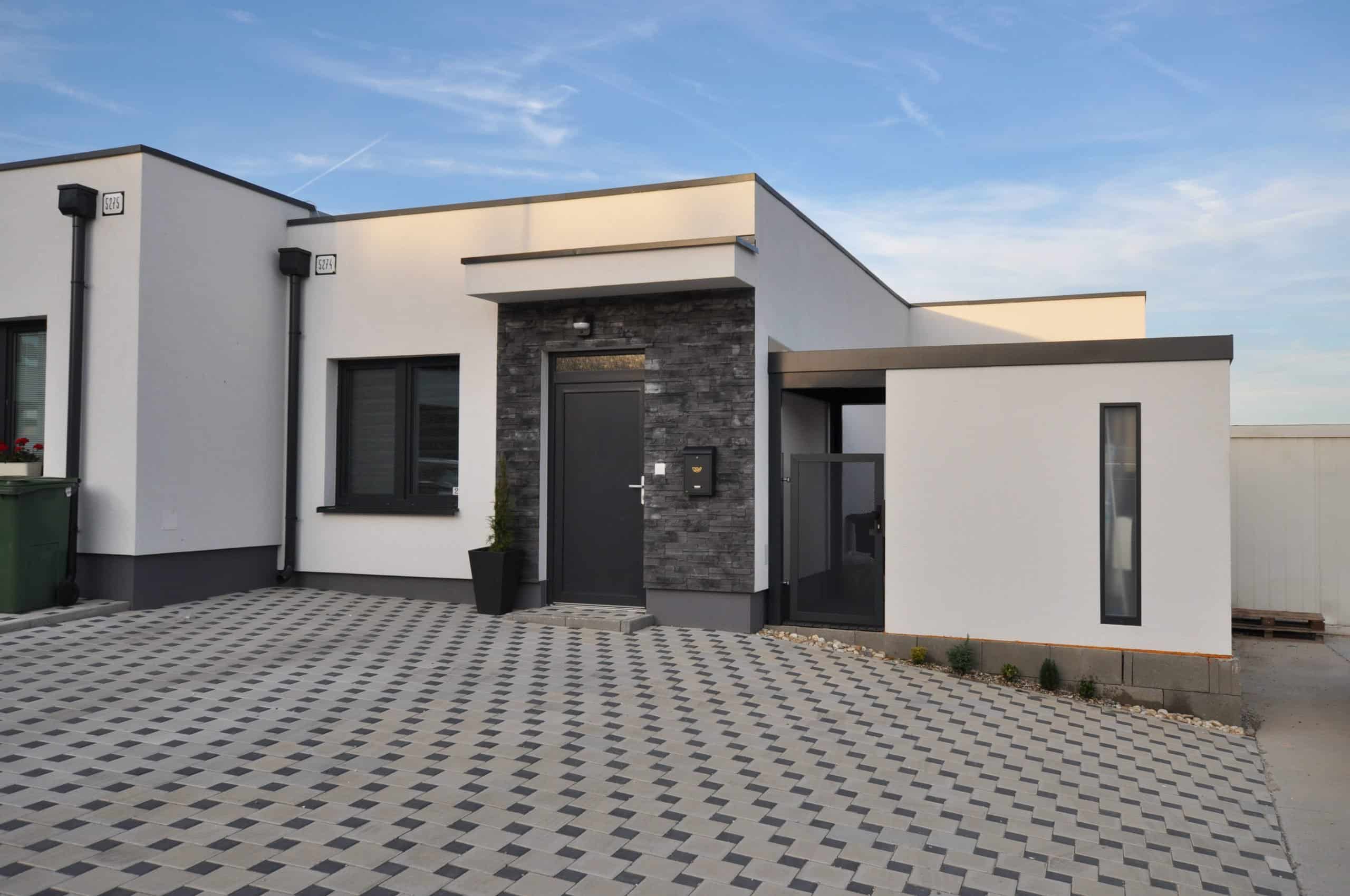 Záhradný domček v bielej omietke pri dome