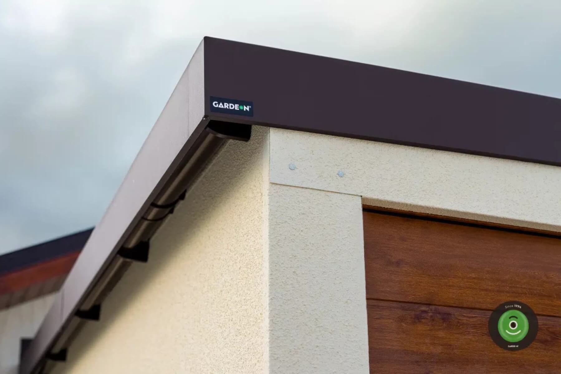 Čiastočne skrytý odkvap na záhradnom domčeku.