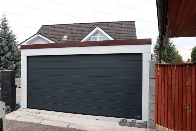 Montovaná dvojgaráž s antracitovou garážovou bránou a hnedou atikou