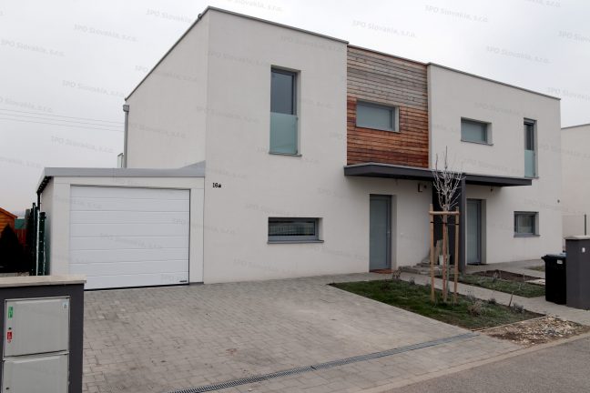 Montovaná garáž pre jedno auto v bielej omietke pri rodinnom dome