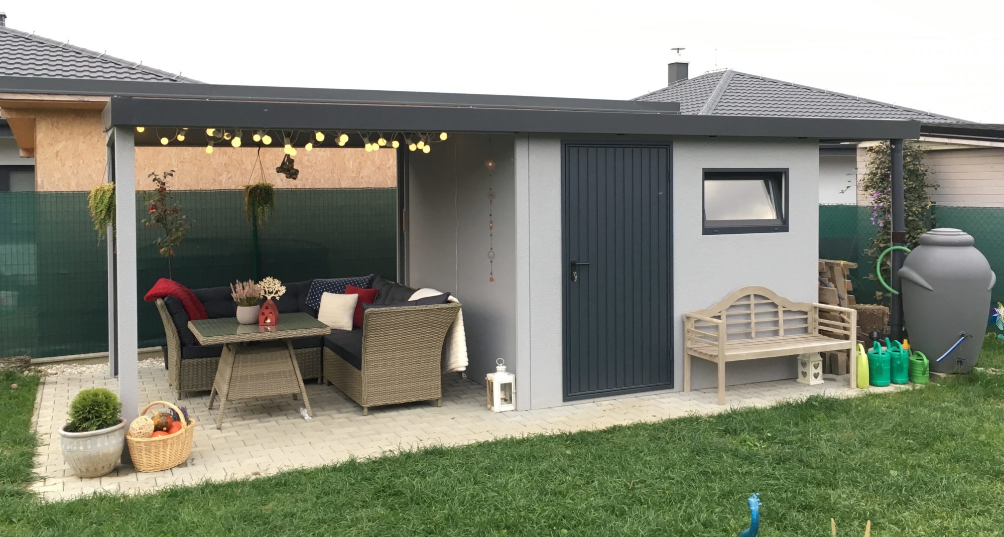 Záhradný domček v svetlosivej omietke so záhradným posedením