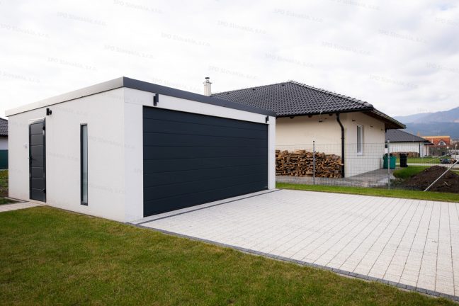 Montovaná garáž GARDEON v bielej omietke pri rodinnom dome