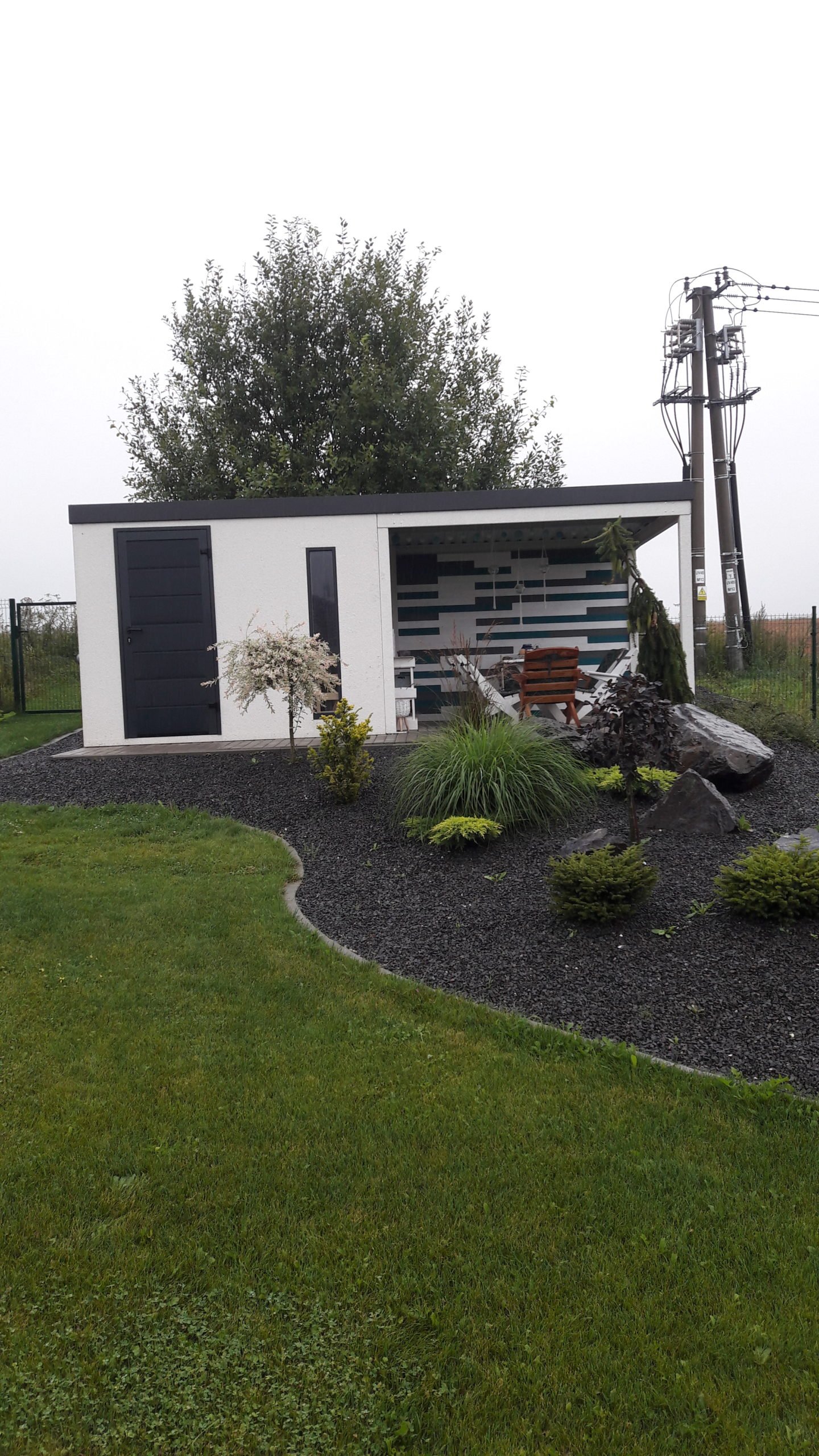 Biely z&aacute;hradn&yacute; domček s prestre&scaron;en&iacute;m za z&aacute;hradkou