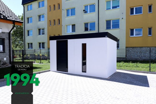 Panelák v pozadí bieleho záhradného domčeka