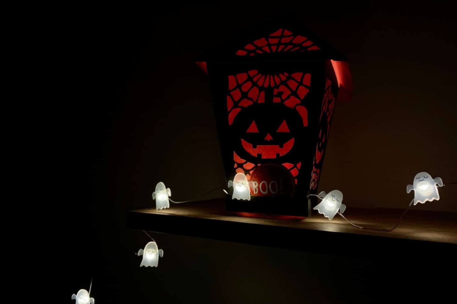 Svetielka v tvare duchov na okne.