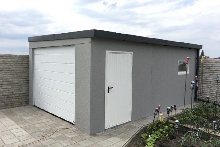 Šedá garáž na záhrade pri plote