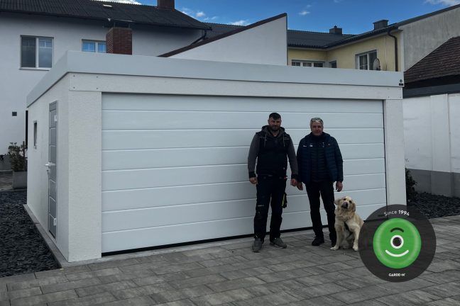 Spokojný zákazník s montážnikom pred novou dvojgarážou GARDEON