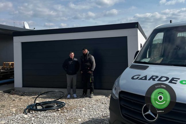Spokojný zákazník s montážnikom pred garážou GARDEON