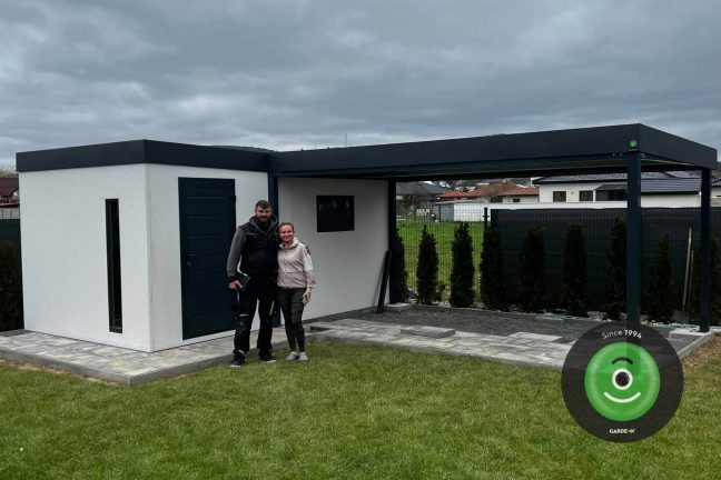 Spokojná zákazníčka s montážnikom pred záhradným domčekom s prístreškom GARDEON
