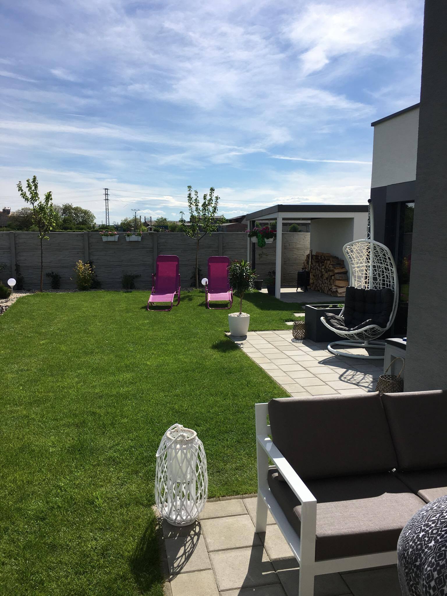 Útulne zariadené okolie záhradky pri záhradnom domčeku s drevom