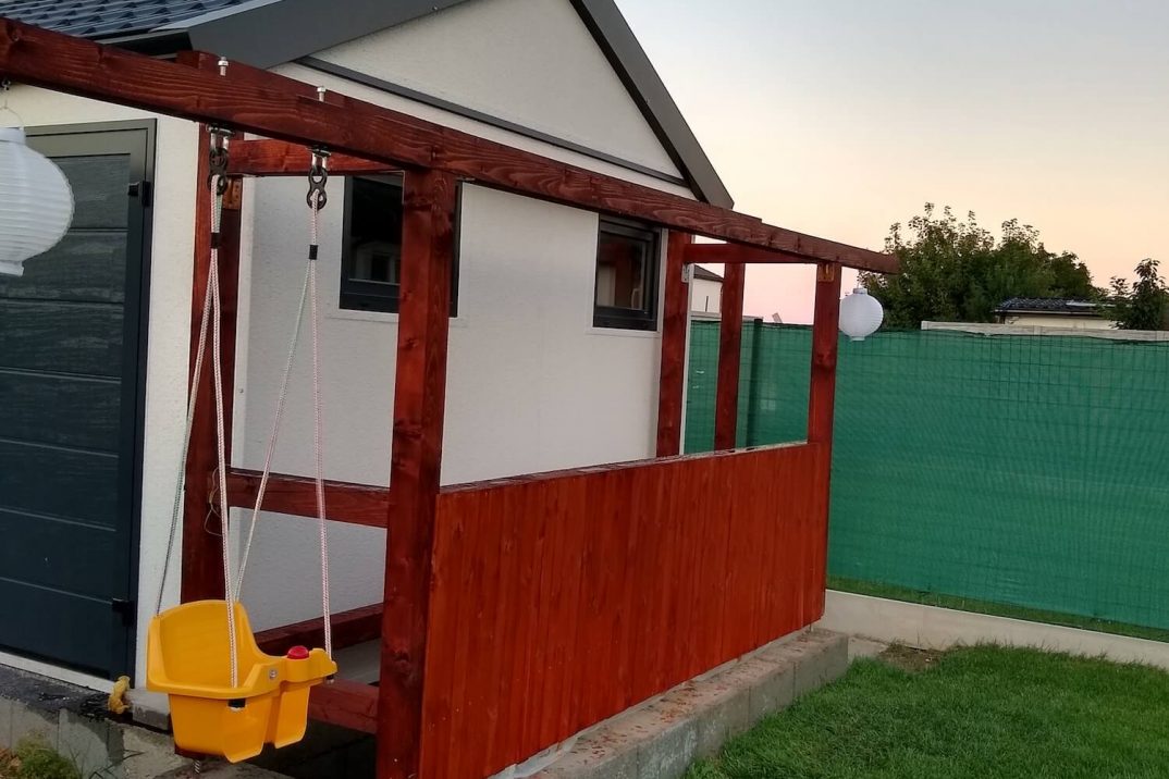 Zavesená žltá hojdačka pri garáži