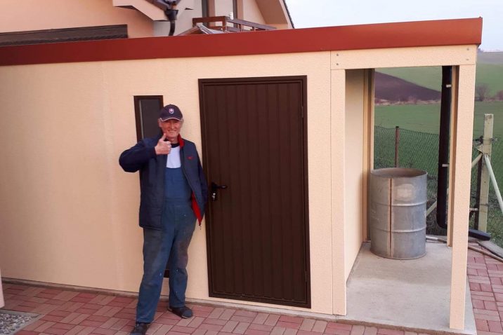 Spokojný zákazník pri svojom záhradnom domčeku s prístreškom