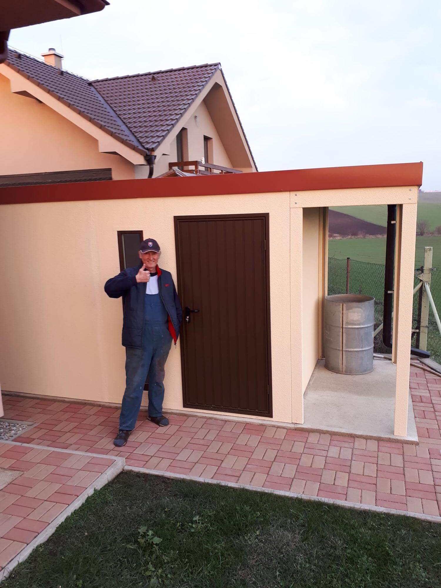 Spokojný zákazník pri svojom záhradnom domčeku s prístreškom