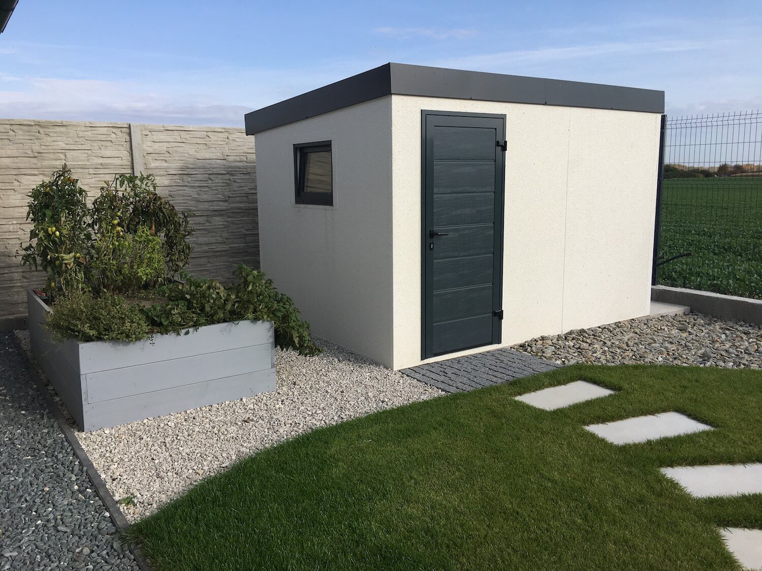 Biely záhradný domček s tmavou atikou z ľavej strany