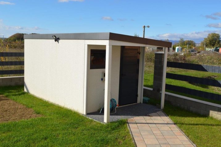 Záhradný domček s prístreškom a hadica na polievanie záhrady