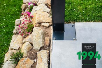 Stĺp ukotvený na podklade pri kameňoch