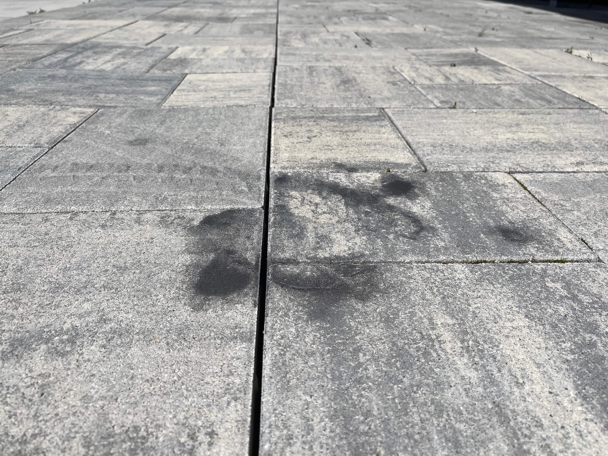 Olejová škvrna na zámkovej dlažbe.