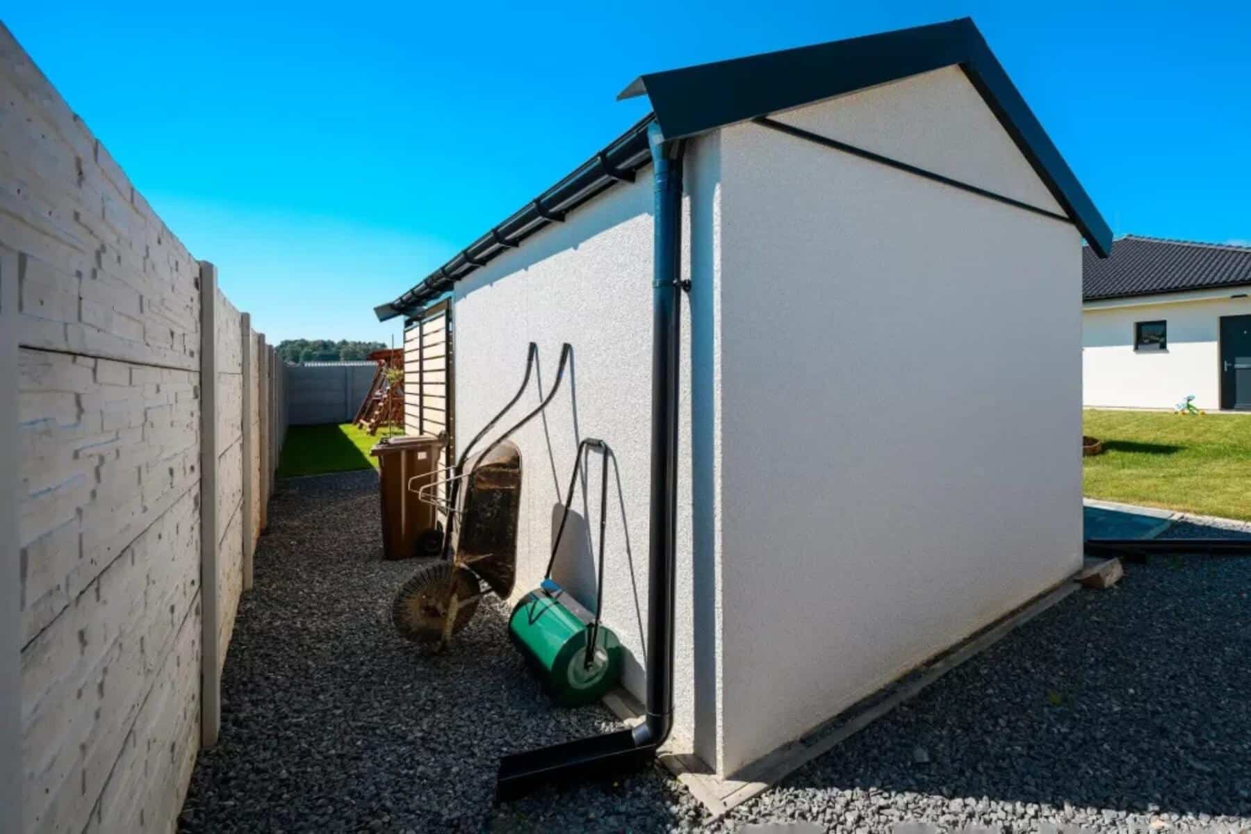 Nádoba na bioodpad a náradie za záhradným domčekom.