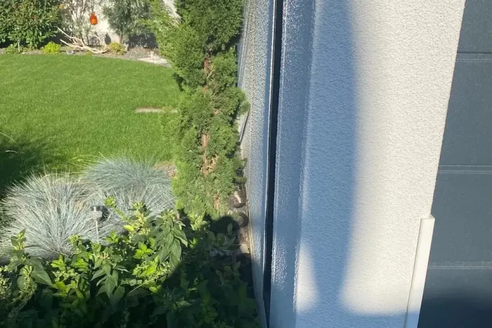 Skleník zboku garáže v bielej omietke