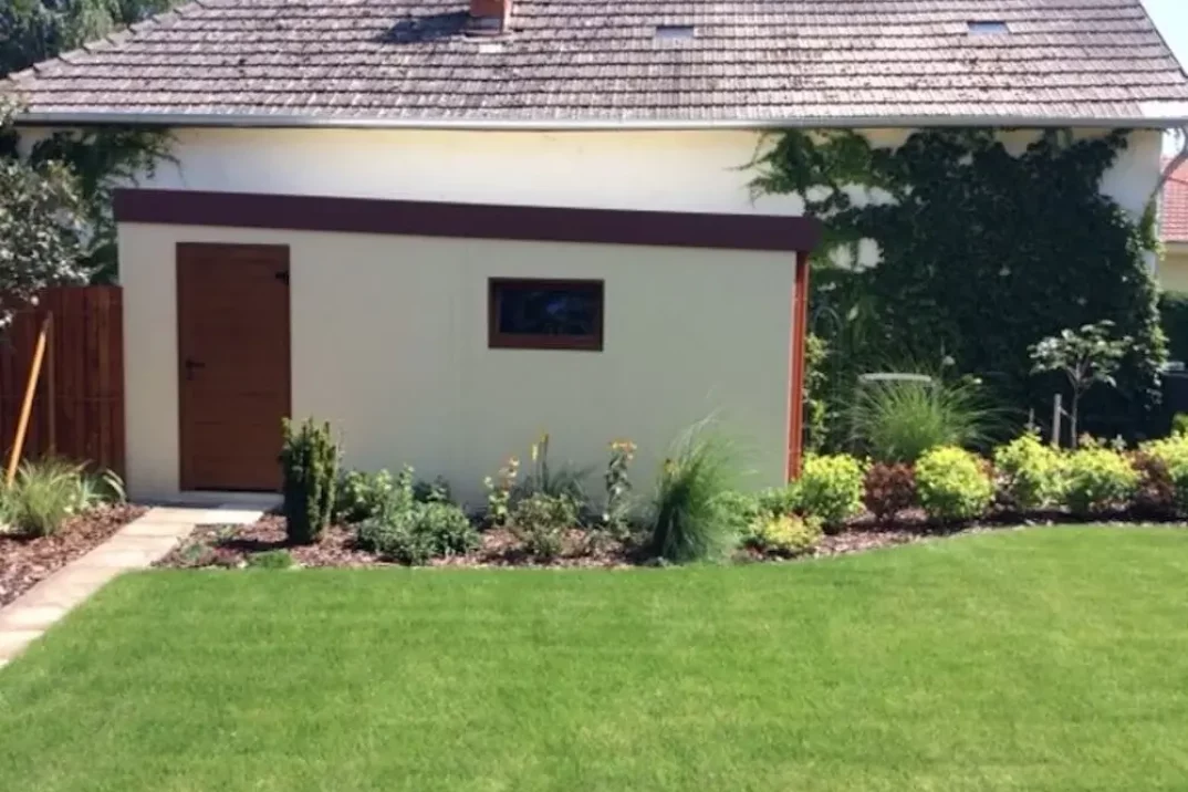 Garáž pre jedno auto s dverami a oknom na záhrade pri bylinkách