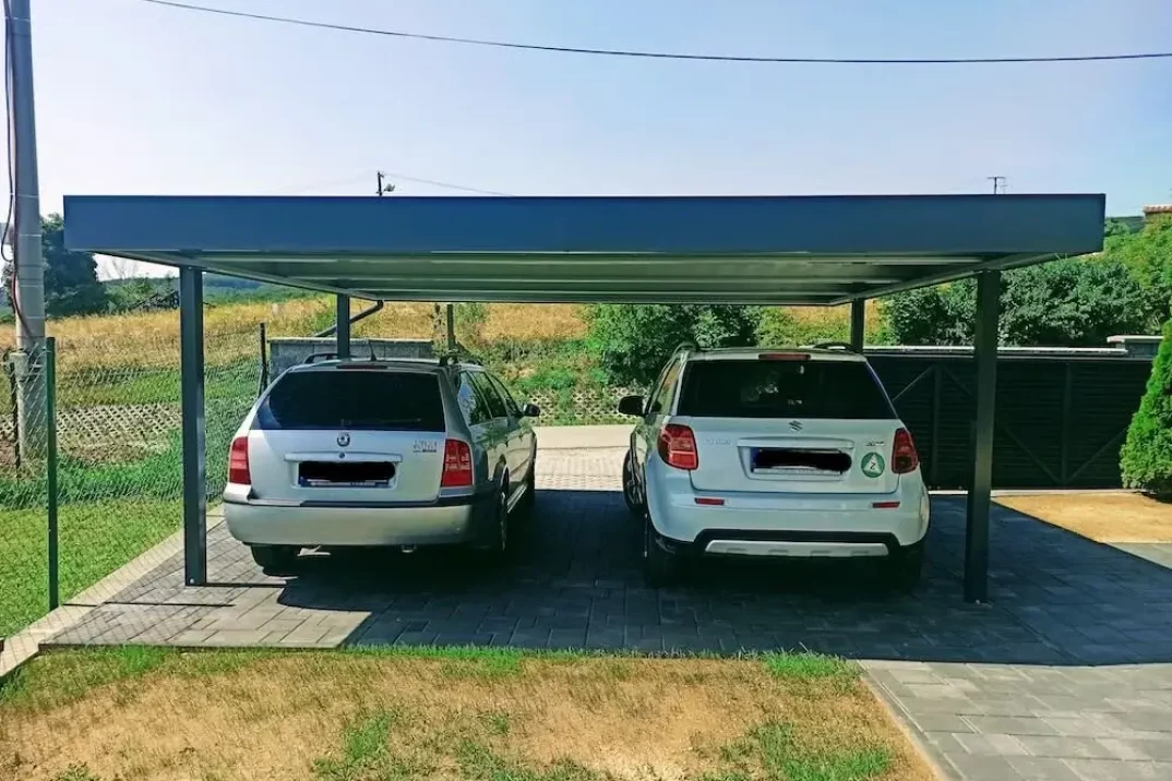 Dve zaparkované autá pod prístreškom SIEBAU zozadu