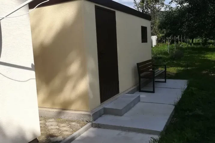 Záhradný domček v žltej omietke na záhrade