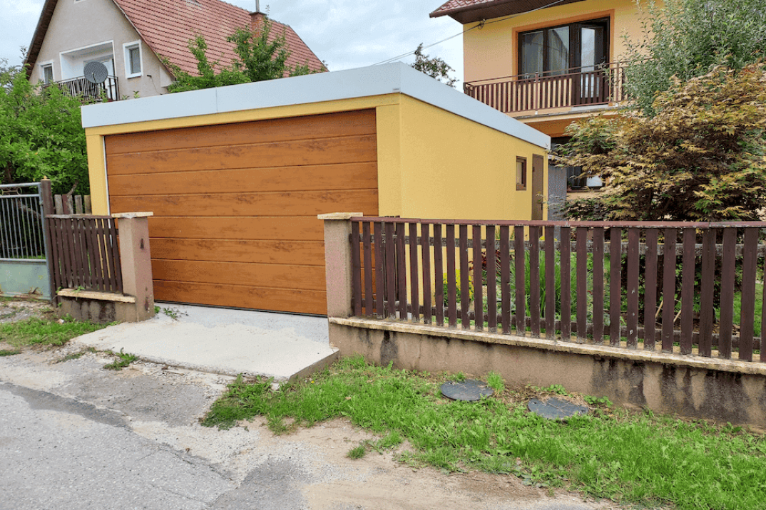 Garáž v žltej omietke medzi plotom