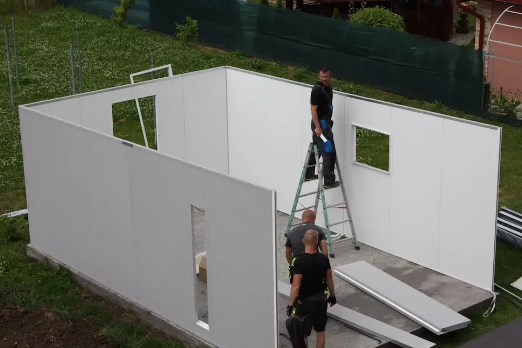 Montážnici montujú steny garáže