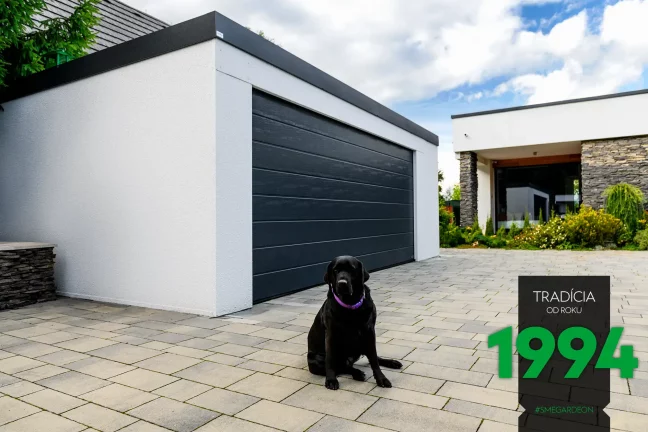 Čierny pes pri dvojgaráži v bielej omietke