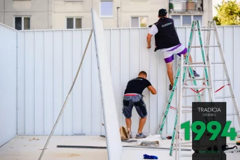 Montážnik na rebríku počas montáže