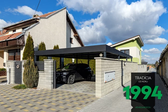 Auto pod prístreškom za murovaným plotom