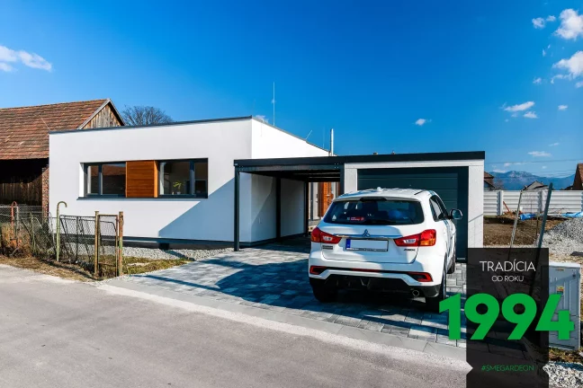 Biele auto pred garážou s prístreškom pri dome