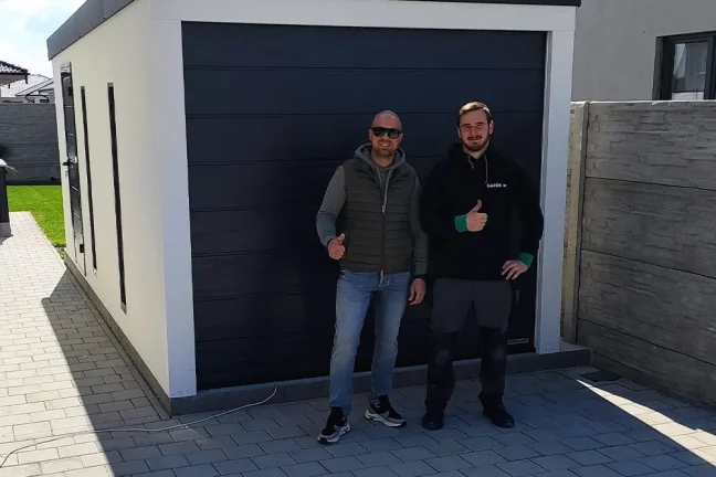 Spokojný zákazník pred garážou s montážnikom