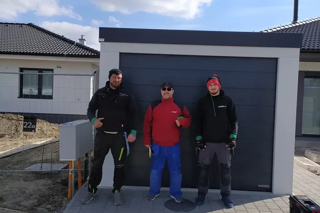 Zákazník s montážnikmi pred garážou