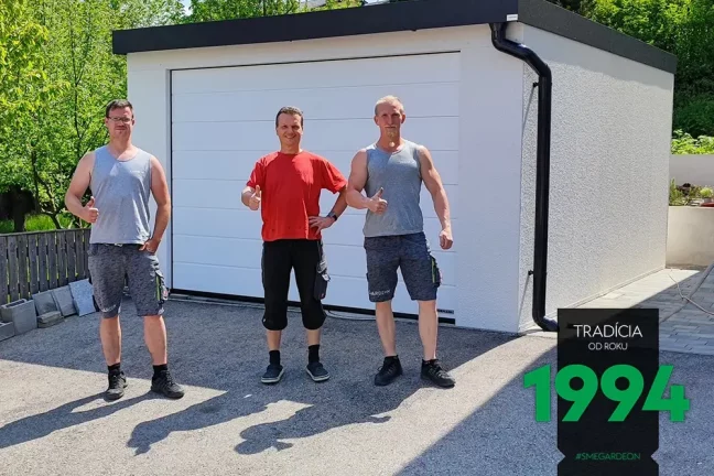 Montážnici so zákazníkom pred bielou garážou