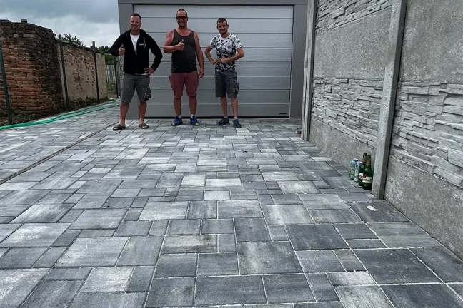 Montážnici so zákazníkom pred garážou