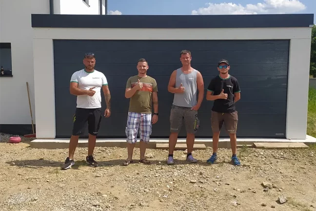 Zákazník s montážnikmi pred garážou