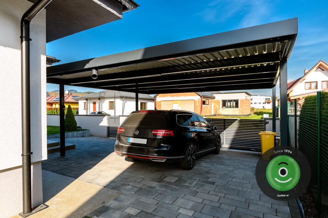 Auto pod prístreškom za samonosnou bránou