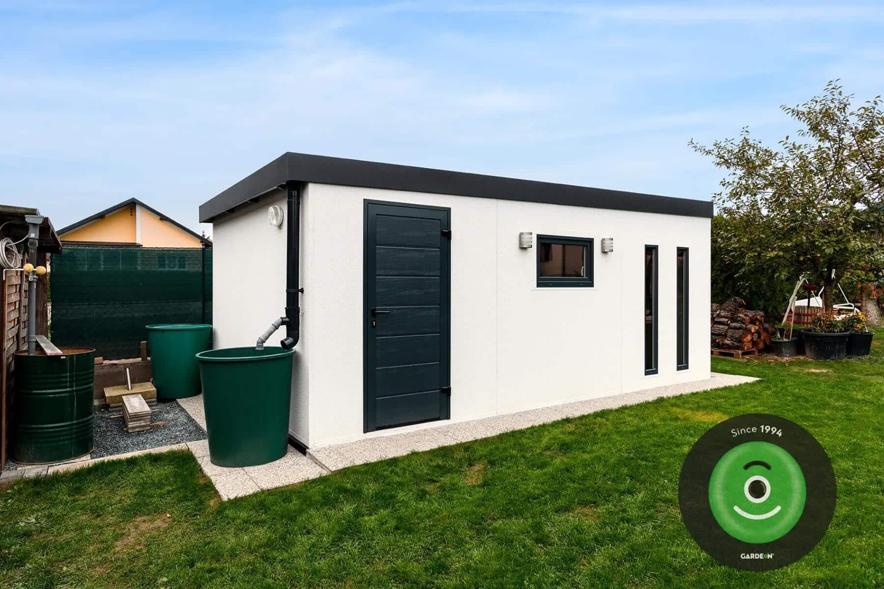 Zachytávanie dažďovej vody do suda pri záhradnom domčeku.