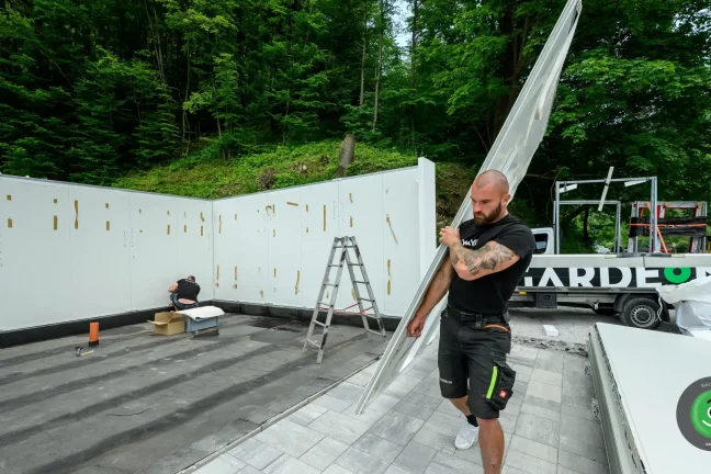 Montážnik prináša izolované steny garáže