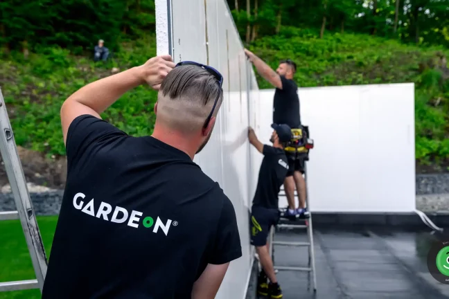 Montážnici osádzajúci steny garáže