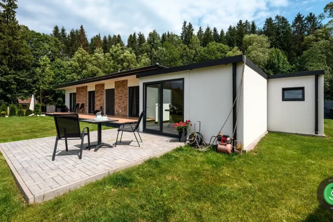 Záhradný domček za garážou s vonkajším posedením.