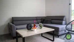 Tmavá pohovka v letnej obývačke v GARDEON domčeku.