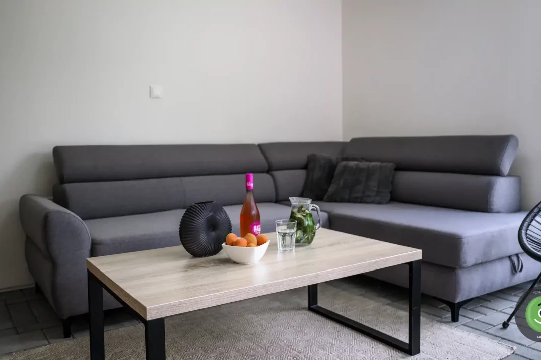 Tmavá pohovka v letnej obývačke v GARDEON domčeku.