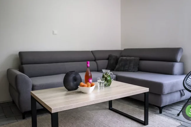 Tmavá pohovka v letnej obývačke v GARDEON domčeku.