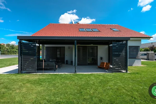 GARDEON pergola s čiernou výplňou s výhľadom na záhradu.